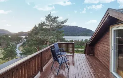 a blue chair sitting on a deck with a view at Gorgeous Home In Eivindvik With Wifi in Eivindvik