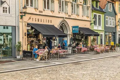 a group of people sitting at tables on a street at Dinbnb Home - History meets Modern I 3-Story Bergen House in Bergen