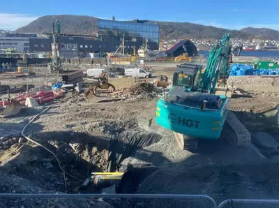 a construction site with a blue bulldozer in the dirt at Dinbnb Home - History meets Modern I 3-Story Bergen House in Bergen