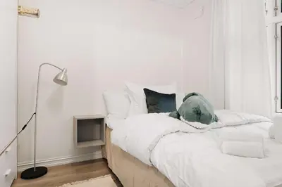a white bedroom with a bed with white sheets and pillows at Dinbnb Home - History meets Modern I 3-Story Bergen House in Bergen