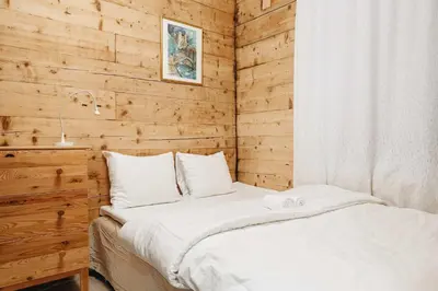 a bed in a room with a wooden wall at Dinbnb Home - History meets Modern I 3-Story Bergen House in Bergen