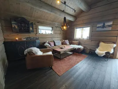 a living room with a couch and a table at Bånseterlodgen in Favang
