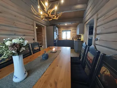 a dining room with a long wooden table and a chandelier at Bånseterlodgen in Favang