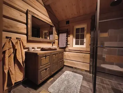 a wooden bathroom with a sink and a shower at Bånseterlodgen in Favang