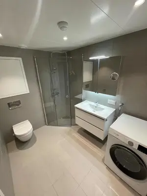 a bathroom with a shower and a toilet and a sink at New Powerhouse apartment in Lade in Trondheim in Trondheim