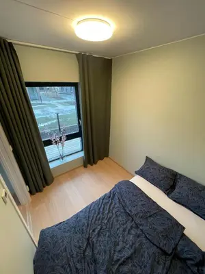 a bedroom with a bed and a large window at New Powerhouse apartment in Lade in Trondheim in Trondheim