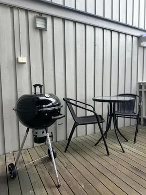 a grill and a table and chairs on a porch at Cozy Apartment in Lillehammer in Lillehammer