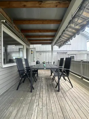 a patio with a table and chairs on a deck at Cozy Apartment in Lillehammer in Lillehammer