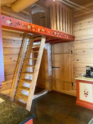 a bunk bed in a log cabin with a ladder at Kvenahytta in Markegardlian