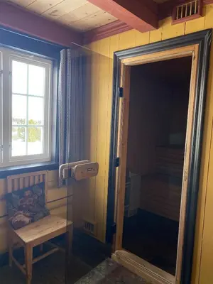 a bathroom with a shower with a mirror and a window at Kvenahytta in Markegardlian