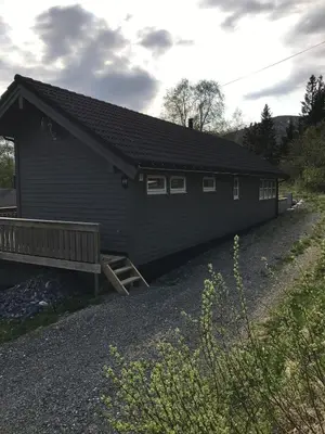 a black building with a bench in front of it at Amazing home in the heart of Nordfjordeid in Nordfjordeid