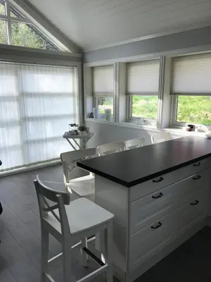 a kitchen with a island with chairs and windows at Amazing home in the heart of Nordfjordeid in Nordfjordeid