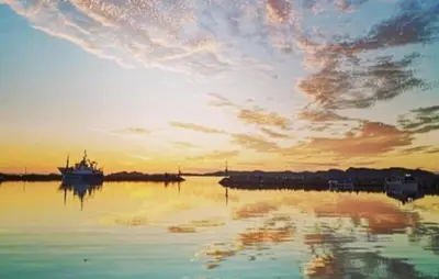 a boat in the water with a sunset in the background at 4 Bedroom Gorgeous Home In Atløy in Herland
