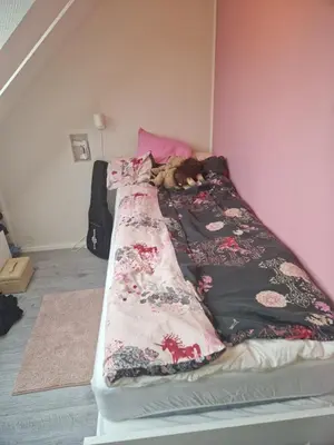 a dog laying on top of a bed at Sentrumsnær stor leilighet in Trondheim