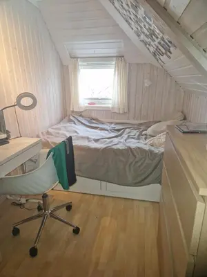 a bedroom with a bed and a desk and a chair at Sentrumsnær stor leilighet in Trondheim