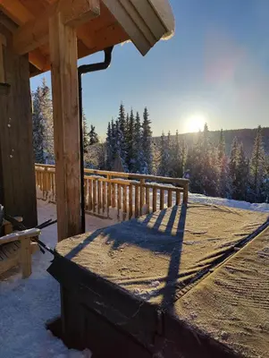a porch of a cabin with snow on the ground at Skogbrynet hytte in Svingvoll