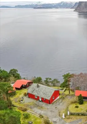 an aerial view of a red barn next to the water at Hardangerfjord panorama 2 in Kvam