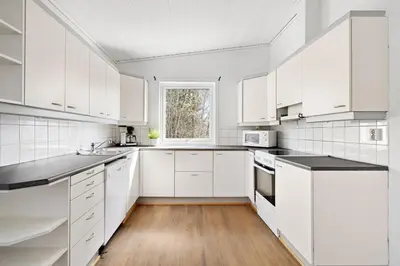 a white kitchen with white cabinets and a window at World Cup Trondheim 2025 in Trondheim