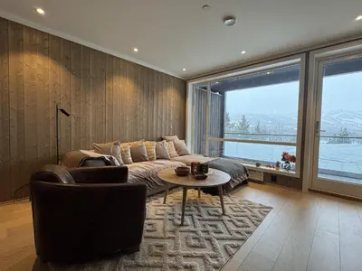 a living room with a couch and a table at Exclusive and cozy apartment central Geilo area in Geilo