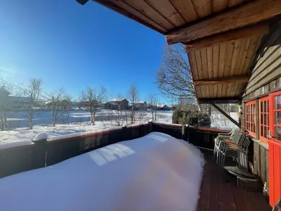 a covered porch with a snow covered bed on it at Charming Mountain Retreat Near Ski Trails And Beitostølen Center in Beitostøl