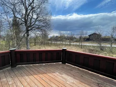 a wooden deck with a view of a field at Charming Mountain Retreat Near Ski Trails And Beitostølen Center in Beitostøl