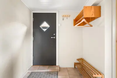 a hallway with a black door and a staircase at Gildeskaal - A Fairytale Stay in Rosendal in Rosendal