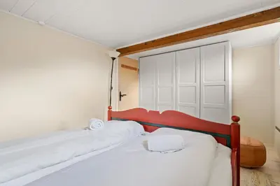 a bedroom with two beds and a closet at Gildeskaal - A Fairytale Stay in Rosendal in Rosendal