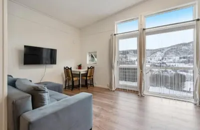 a living room with a couch and a large window at Guesthouse-Ølen, 2 bedroom in Dørheim