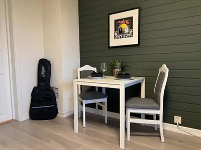 a table and two chairs and a guitar in a room at Appartment with garden in Malvik