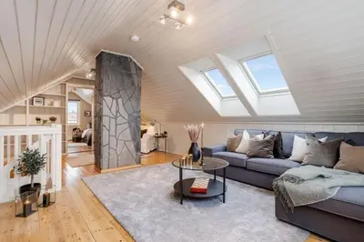 a living room with a blue couch and a skylight at Trondheim VM-arena in Trondheim