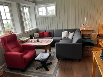 a living room with a couch and a table and chairs at Skiidyll Med Utsikt Og Peis in Beitostøl