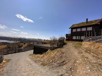 a dirt road next to a house on a hill at Skiidyll Med Utsikt Og Peis in Beitostøl