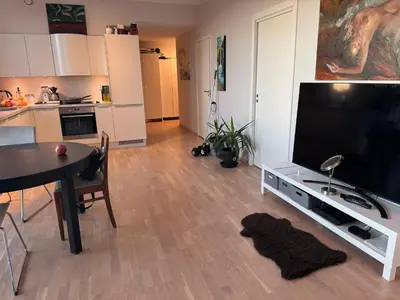 a living room with a large flat screen tv and a table at Near Granåsen in Trondheim