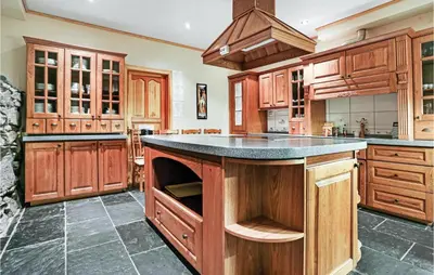 a large kitchen with wooden cabinets and a large island at 10 Bedroom Amazing Home In Ølen in Ølen