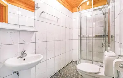 a bathroom with a sink and a toilet and a shower at 10 Bedroom Amazing Home In Ølen in Ølen