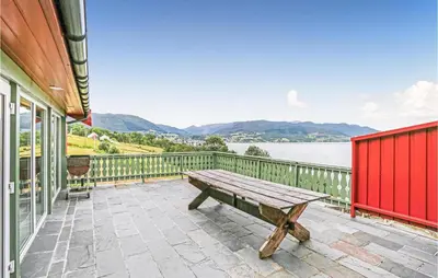 a picnic table on a patio with a view of the water at 10 Bedroom Amazing Home In Ølen in Ølen