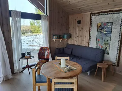 a living room with a blue couch and a table at Rabbelia by Norgesbooking - cabin in great hiking and skiing area in Ål