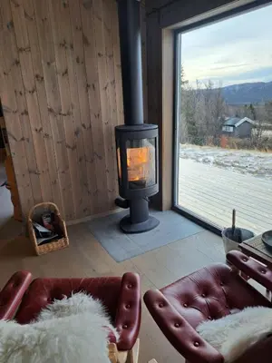 a living room with a fireplace and a couch and a window at Rabbelia by Norgesbooking - cabin in great hiking and skiing area in Ål