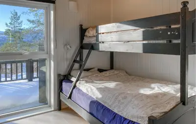 a bunk bed in a room next to a window at Cozy Home In Stryn With Sauna in Stryn