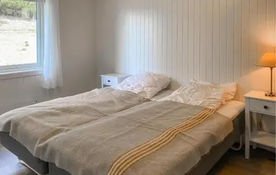 a large bed in a bedroom with a window at Gorgeous Home In Åheim in Åheim