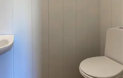 a bathroom with a white toilet and a sink at Gorgeous Home In Åheim in Åheim
