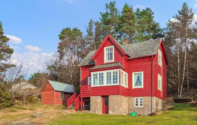 a red house sitting on top of a field at Amazing Home In Kysnesstrand With Wifi in Oppheim