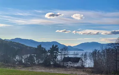 a house in a field with a view of the water and mountains at Amazing Home In Kysnesstrand With Wifi in Oppheim