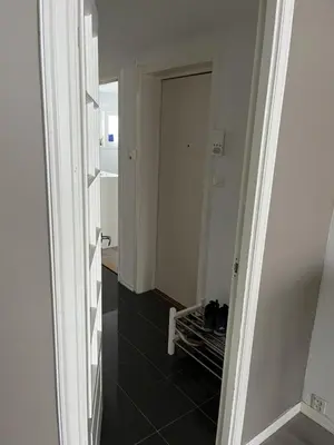 a hallway with a door and a black tile floor at Trondheim in Trondheim