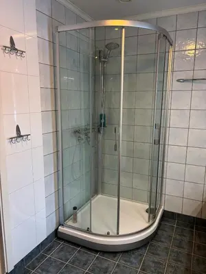 a shower with a glass door in a bathroom at Fjærestua in Hitra
