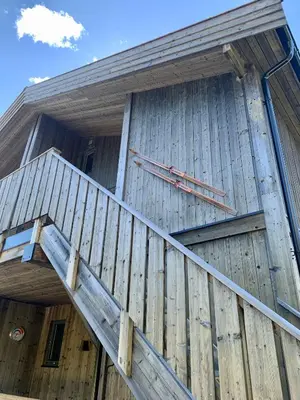 a wooden building with stairs on the side of it at Sjusjøen Hytteutleie AS in Sjusjøen