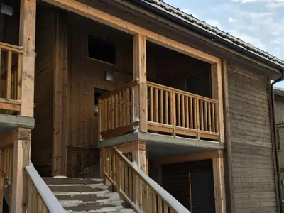 a log cabin with a deck on the side of it at Sjusjøen Hytteutleie AS in Sjusjøen