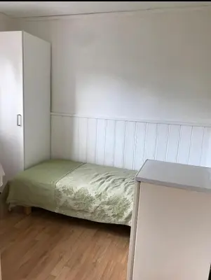 a small bedroom with a bed and a table at Cozy small bedroom flat in Trondheim