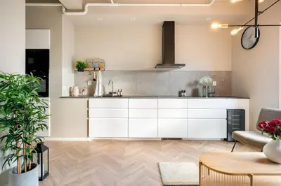 an open kitchen with white cabinets in a living room at 3F - In the heart of Trondheim in Trondheim
