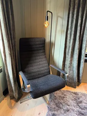 a chair sitting in a room next to curtains at Smart and beautiful micro house - Great base for mountain adventures in Hedalen